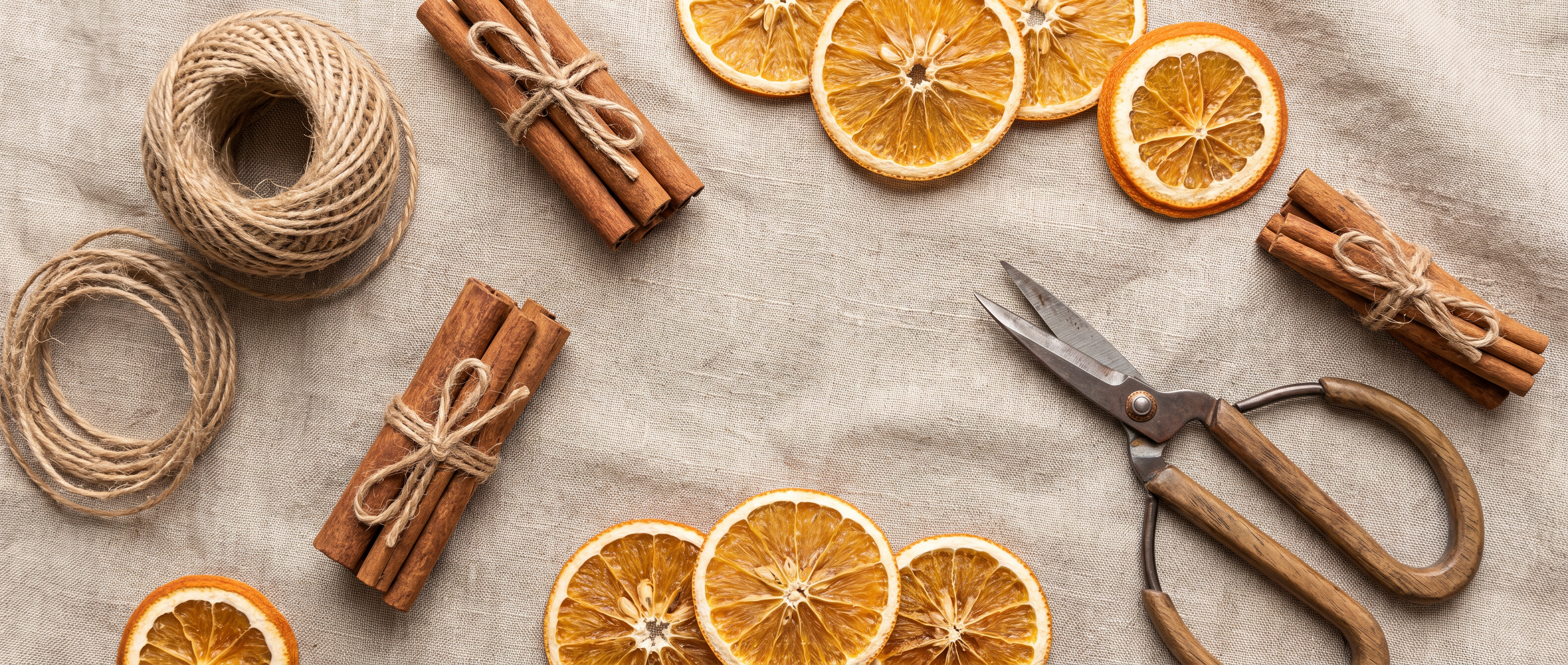Cinnamon sticks and dried orange slices arranged on linen