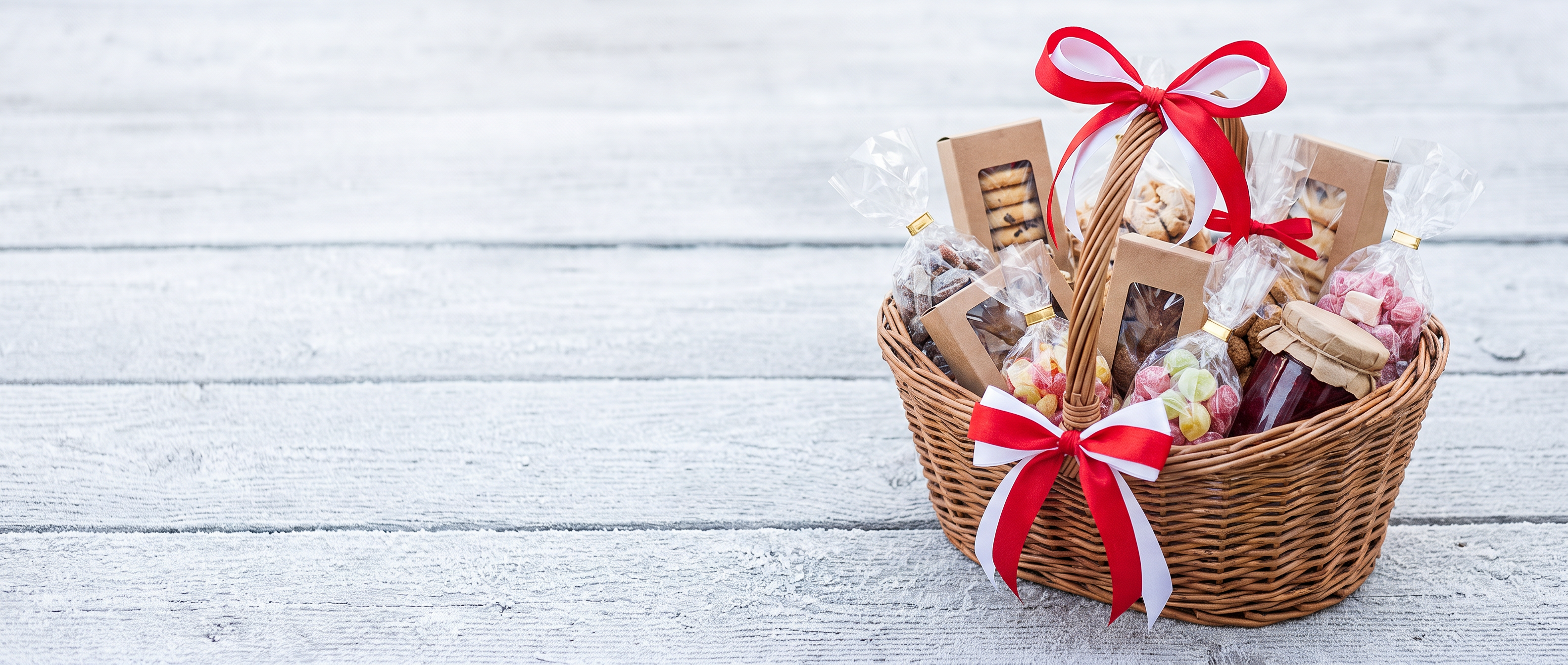 A gift basket of cookies and treats tied with a red and white ribbon